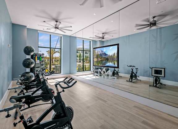 a workout room with mirrors and weights on a wooden floor at Altis Grand Suncoast, Land O' Lakes, 34638