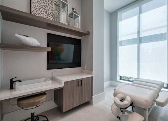 a treatment room at a hospital with a large window and a sink and a chair at Altis Twin Lakes Apartments, Kissimmee