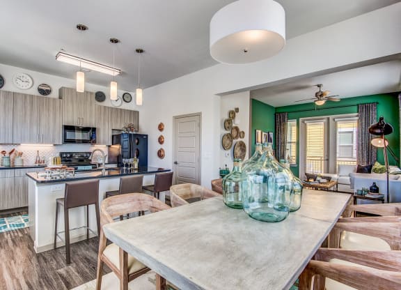 Apartments Lewisville TX - Hebron 121 Station - Modern Kitchen With Sleek Counters and Dining Room Table Equipped With Wooden Chairs
