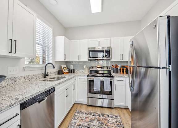 A kitchen with white cabinets and stainless steel appliances.