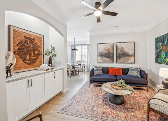 A living room with a couch, a coffee table, and a painting on the wall.