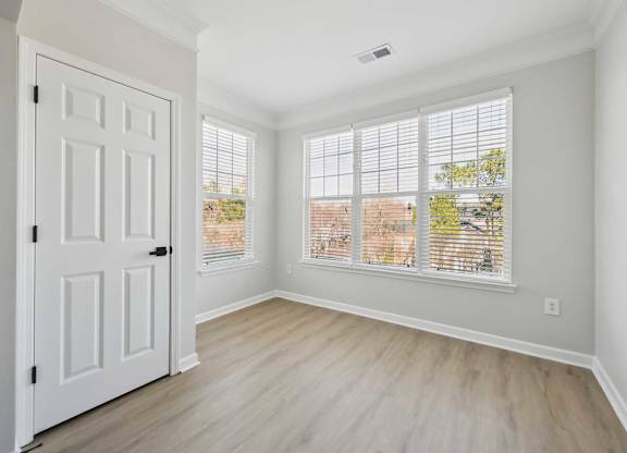 A room with a white door and a window with blinds.