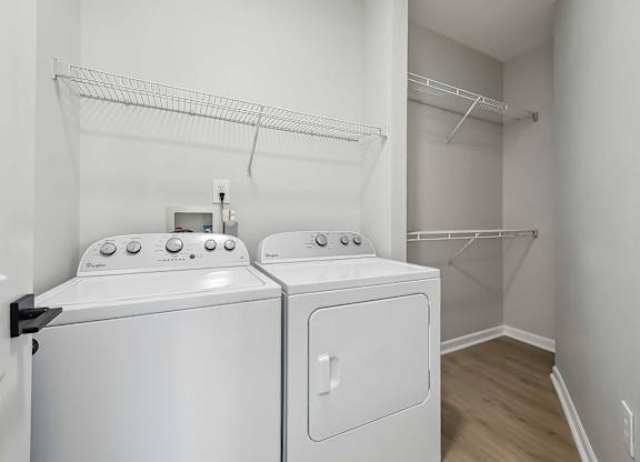 Chapel Hill, NC, Luxury Apartments With In-Unit Washer and Dryer - Reserve at Meadowmont - Laundry Closet with Full-Size Washer, Dryer, and Built-In Wire Racks on the Walls.
