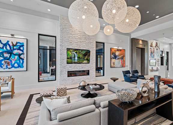the living room has a stone fireplace and modern furniture at Altis Twin Lakes Apartments, Kissimmee, FL 34744