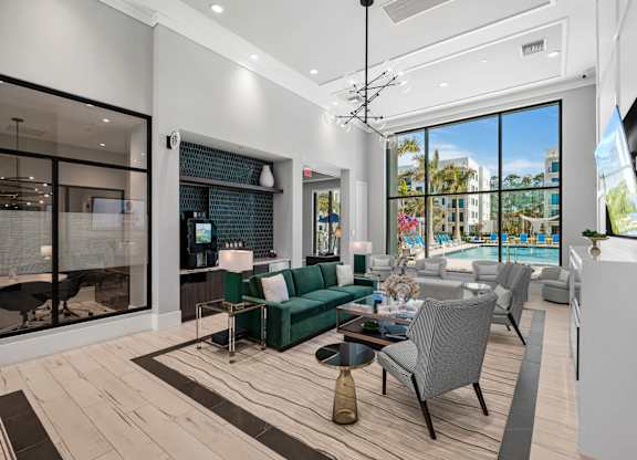 A modern living room with a green sofa and a view of the outside.