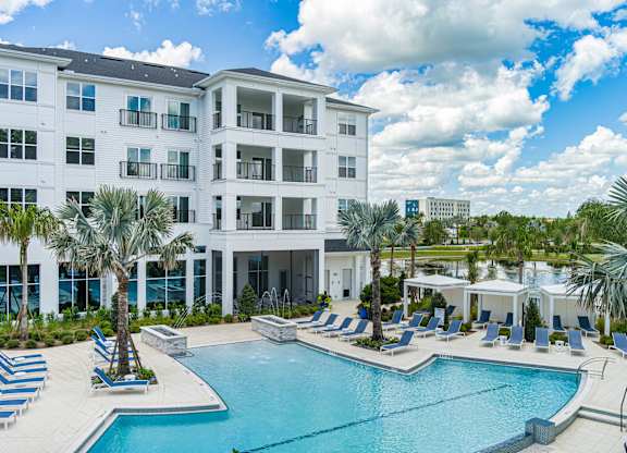 A large white building with a pool in front.