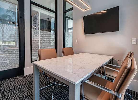 a conference room with a marble table and chairs at Altis Twin Lakes Apartments, Kissimmee, 34744