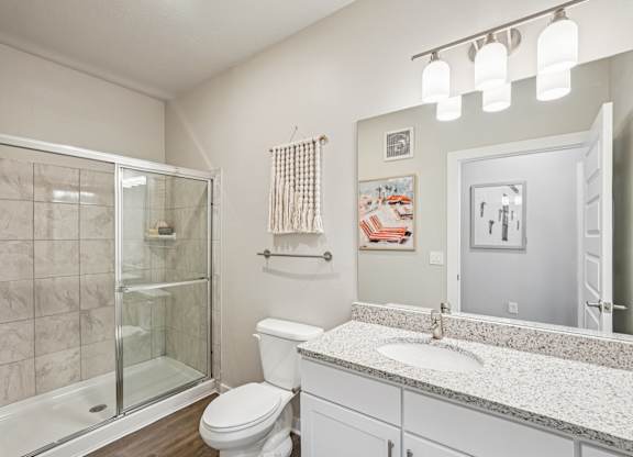 A bathroom with a toilet, sink, and shower.