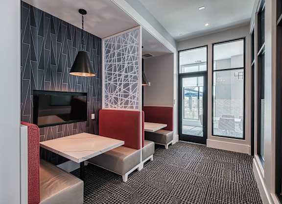 a dining room with tables and chairs and a television at Altis Grand Suncoast, Land O' Lakes, FL