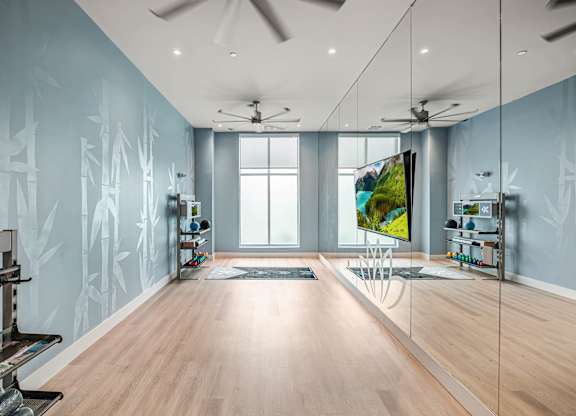 A modern room with a wooden floor and a wall mural of trees.