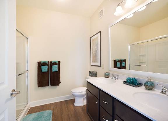 A bathroom with a white sink, toilet, and a mirror.