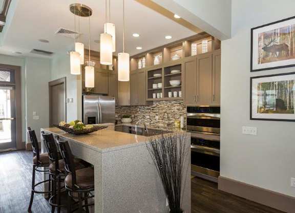 A kitchen with a bar area and a framed picture on the wall.
