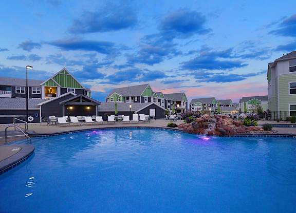A swimming pool in front of a building with a green roof.