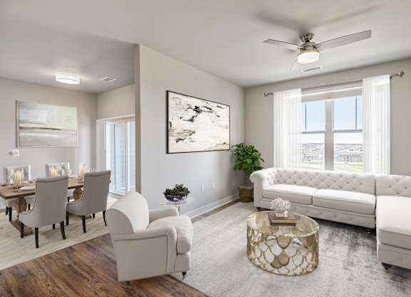 A living room with a white sofa, a coffee table, and a painting on the wall.