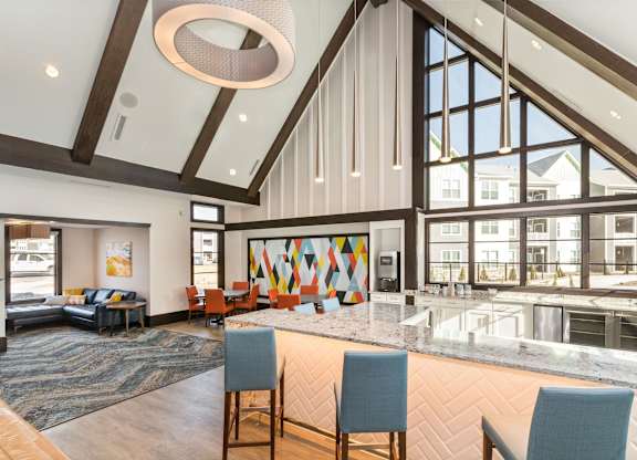 A large, modern room with a high ceiling and a long table with chairs.