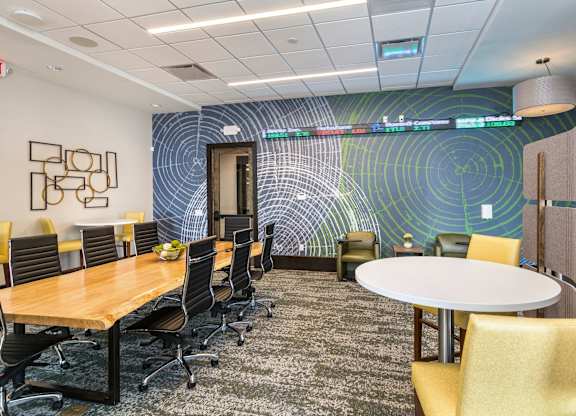 A conference room with a long table surrounded by chairs.