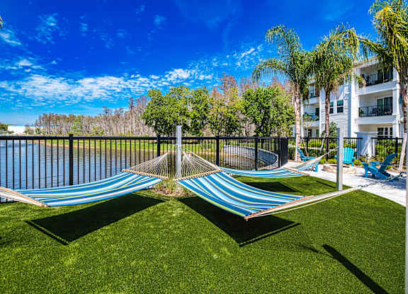 a composite image of a hammock on the grass next to a pool at Altis Grand Suncoast, Land O' Lakes, 34638