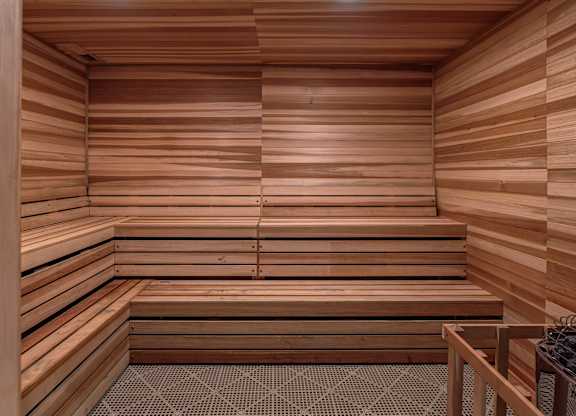 A wooden sauna with benches and a stone floor.