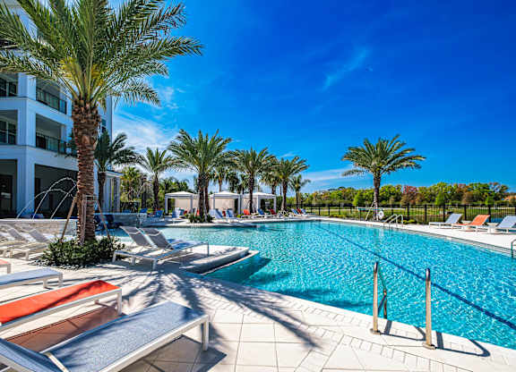 a swimming pool with lounge chairs and palm treesat Altis Grand Suncoast, Florida