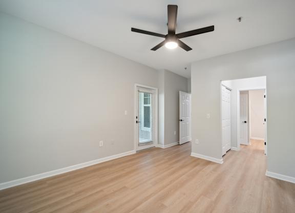 a living room with wood floors and a ceiling fan