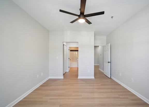 a living room with white walls and a ceiling fan