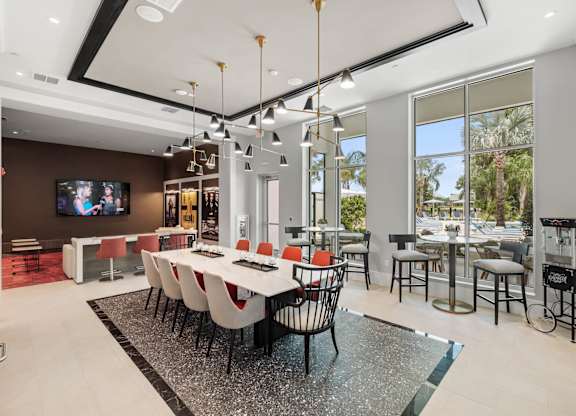 A modern dining room with a long table and chairs.