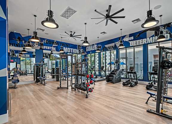 a gym with weights and cardio machines and lights on the ceiling at Altis Santa Barbara, Naples, FL