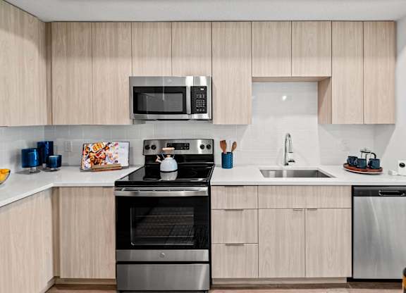 A modern kitchen with wooden cabinets and stainless steel appliances.
