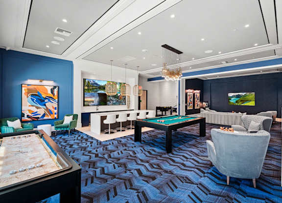 a game room with a pool table and couches at Altis Santa Barbara, Florida