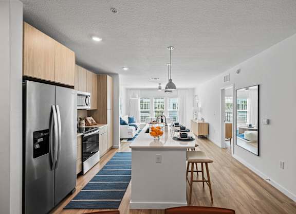 an open kitchen and dining area with a large island and stainless steel appliances at Altis Grand Suncoast, Florida