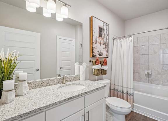 A bathroom with a white toilet, sink, and bathtub.