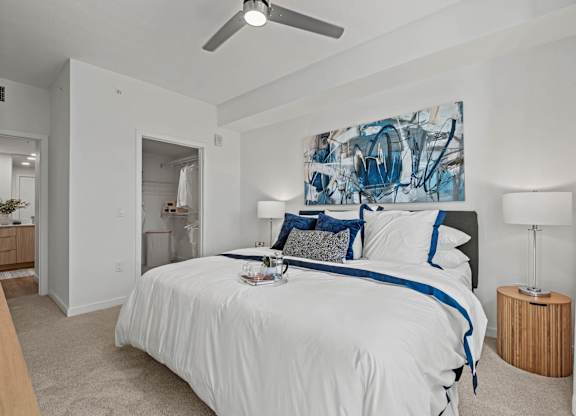 A bedroom with a large bed and a painting on the wall.