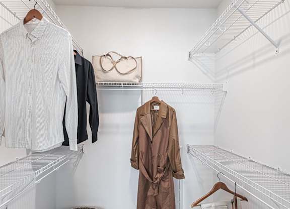 a walk in closet with coats and jackets hanging on the wall  at Altis Grand Suncoast Apartments, Florida, 34638