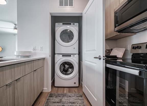 a small laundry room with a washing machine in it at Altis Grand Suncoast, Land O' Lakes, FL