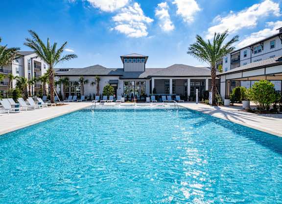 A large swimming pool in front of a building with palm trees.at Altis Grand Lake Willis, Orlando, FL