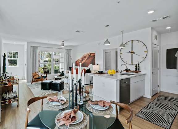 a living room and kitchen with a large clock on the wall at Altis Grand Suncoast, Florida