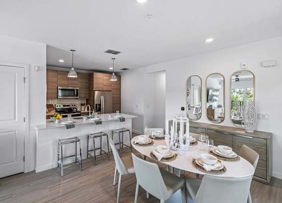 A modern kitchen with a dining table set for four.