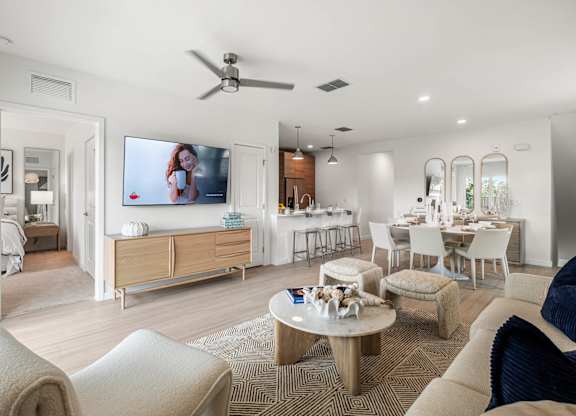 A modern living room with a flat screen TV mounted on the wall.