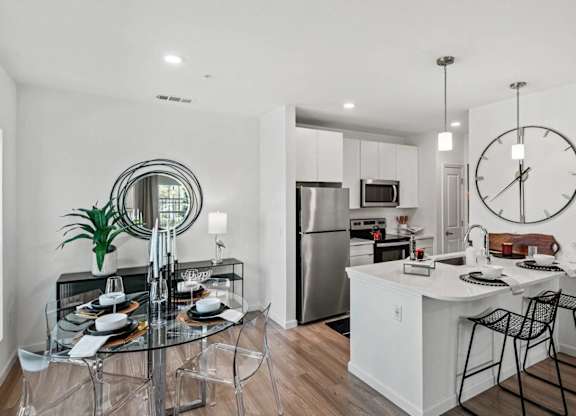 an open kitchen and dining room with a large clock on the wall at Altis Grand Lake Willis, Orlando, 32821