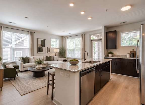 A modern kitchen with a large island and a dining area with a table and chairs.