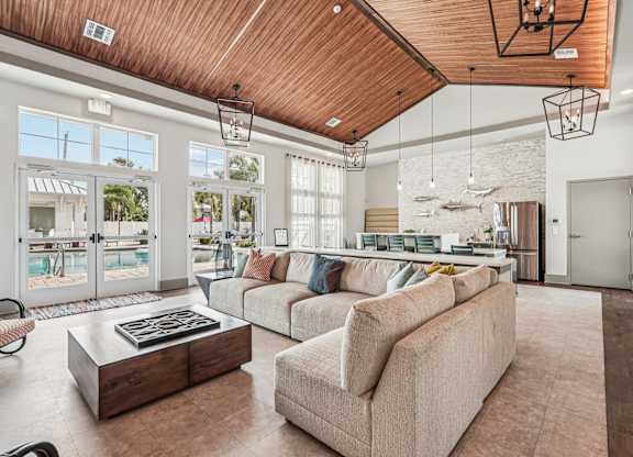 A living room with a wooden ceiling and a large window.