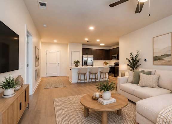 A living room with a white couch, a wooden coffee table, and a ceiling fan.