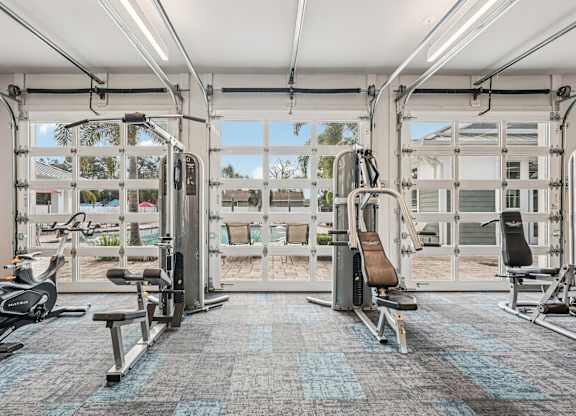 A gym with a variety of equipment including treadmills, stationary bikes, and weight machines.