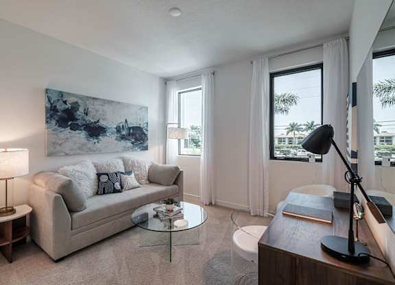 a living room with a couch and a table at Altis Santa Barbara, Naples, 34104