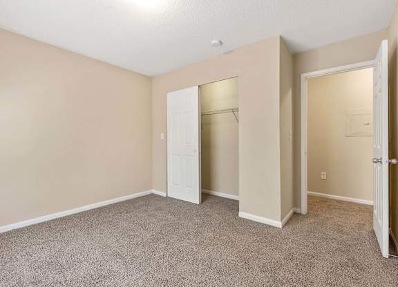 A room with a carpeted floor and a white door.