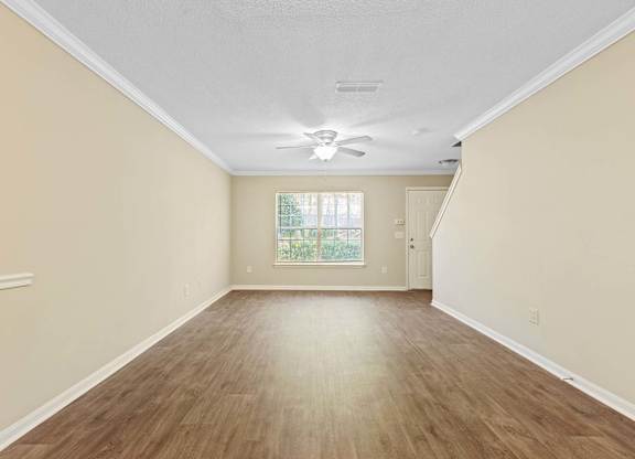 A room with wooden flooring and a ceiling fan.