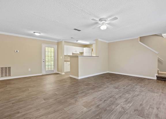 A spacious room with a ceiling fan and lighting fixtures.
