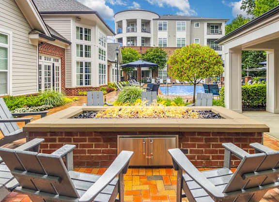 A backyard with a fire pit and chairs.