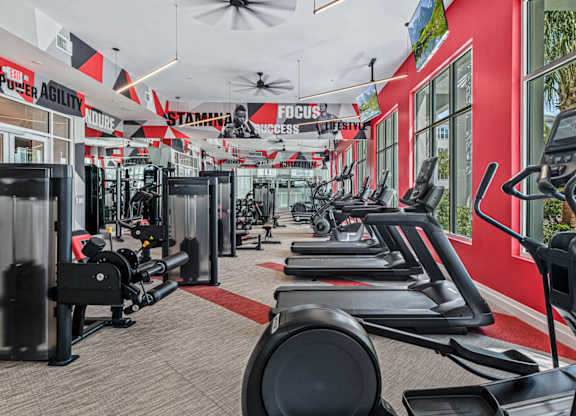 a gym with cardio equipment and a row of windows at Altis Grand Lake Willis, Orlando, FL