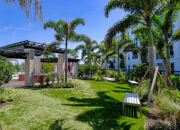 a garden with grass and palm trees at Altis Grand Lake Willis, Florida, 32821